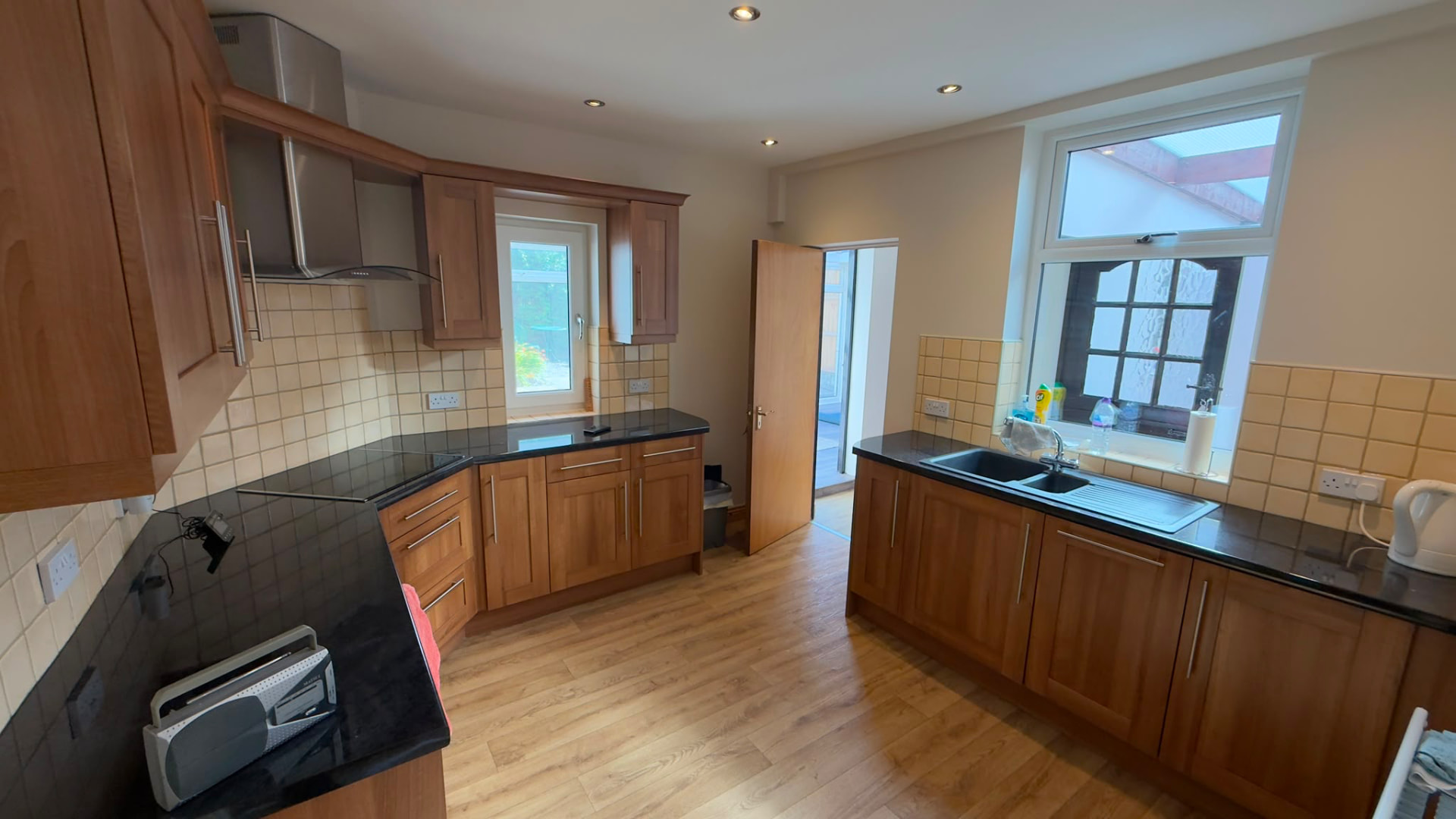 Shared kitchen with wooden units, sink and worktop space