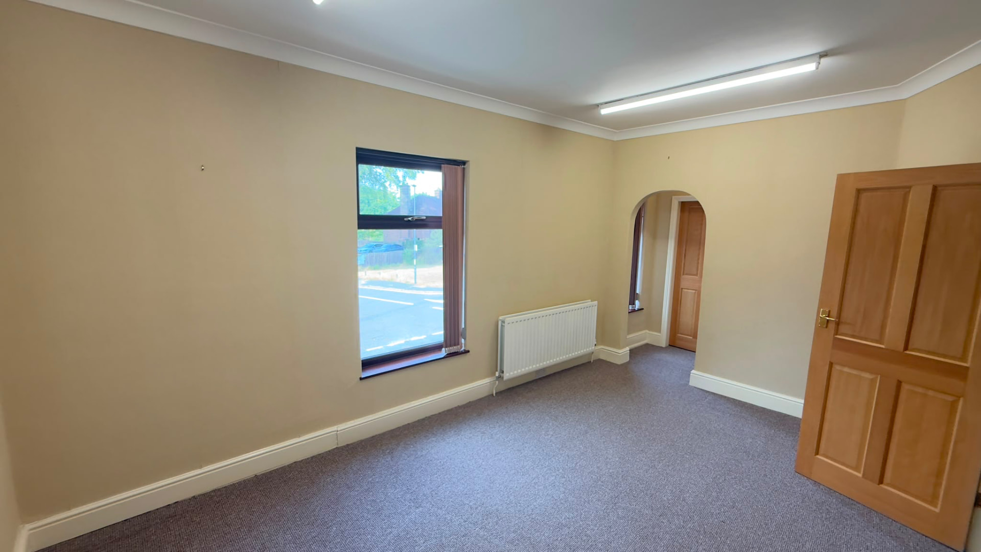 Large carpeted office with archway through to a second space