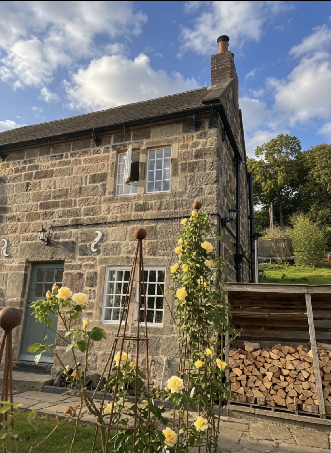 The Duffield office — a stone cottage with climbing yellow roses and a sage green door